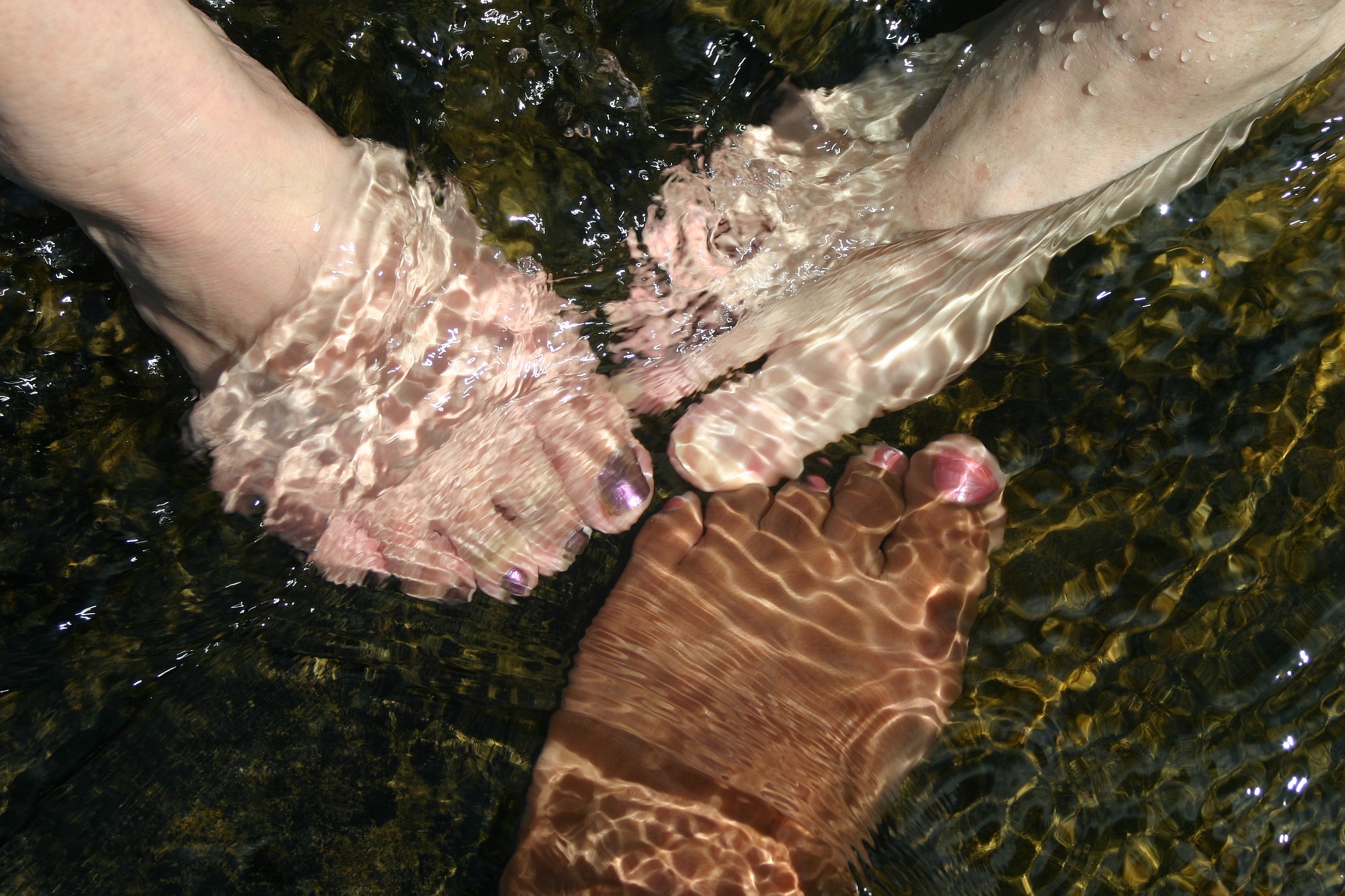 feet underwater with painted toenails