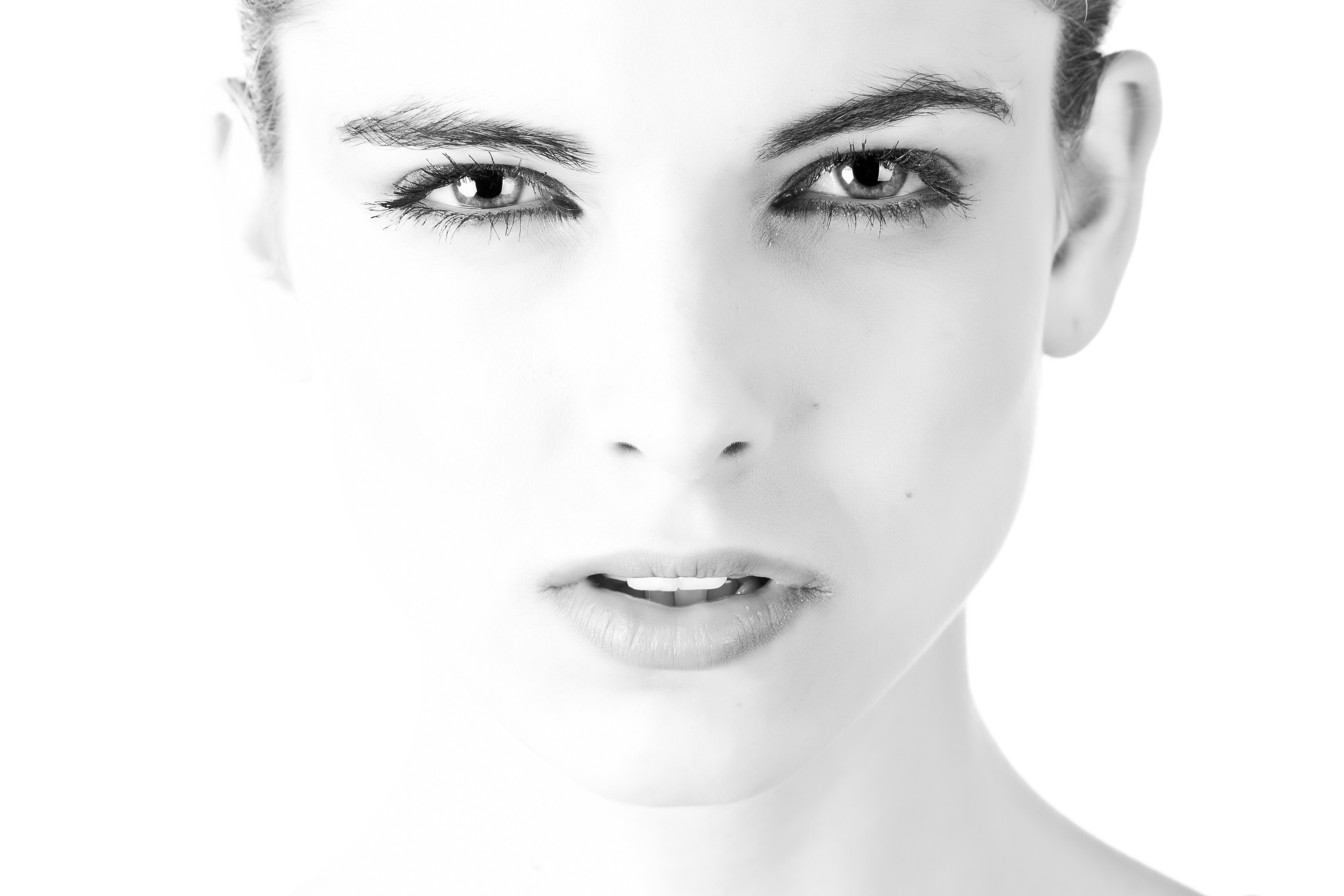 Black and white photo of beautiful woman with intense gaze and sculpted eyebrows