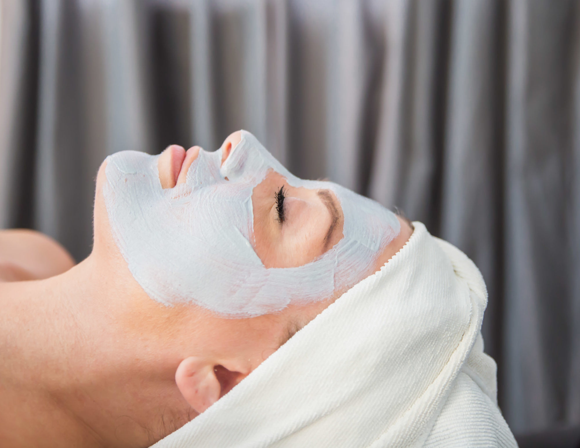 Woman with a clay face mask relaxing at Urban Oasis Day Spa