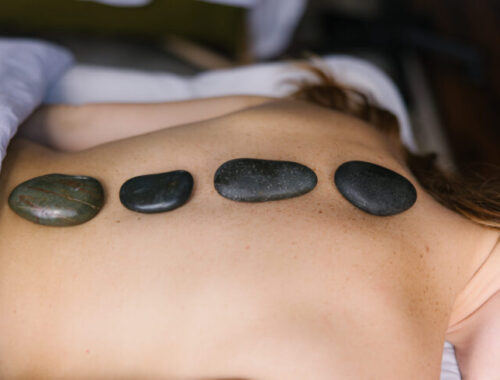 Woman receiving a hot stone massage at Urban Oasis Day Spa in Nashville for a relaxing Mother’s Day treatment