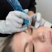 Woman receiving a permanent eyeliner treatment at a professional beauty studio- Urban Oasis Nashville