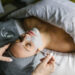 Woman relaxing in a spa bed while receiving a pumpkin enzyme facial, esthetician gently applying treatment mask for smooth, glowing skin at Urban Oasis Nashville.