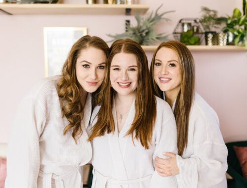 Women enjoying a spa day in Nashville at Urban Oasis wearing robes and smiling together