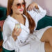 Woman in a white spa robe relaxing with champagne at Urban Oasis Nashville day spa, representing self-care, stress relief, and burnout recovery.