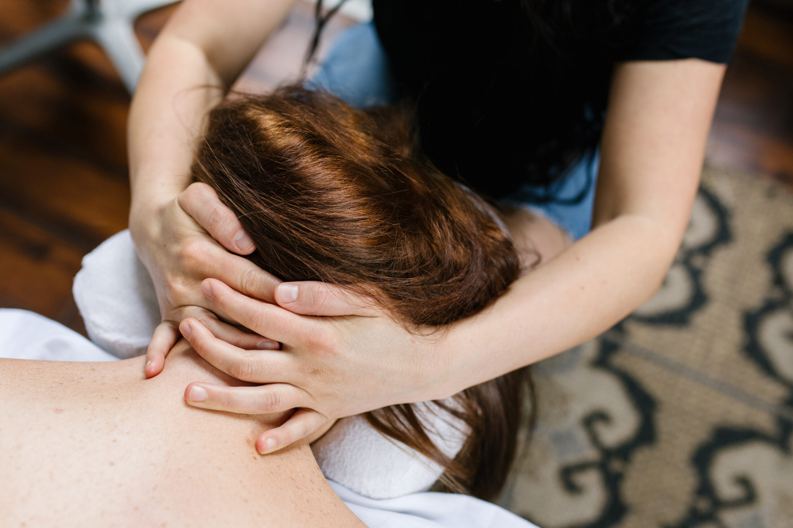 Massage therapist performing a customized neck massage on a client during a relaxing treatment at Urban Oasis Nashville, a boutique day spa in Nashville.