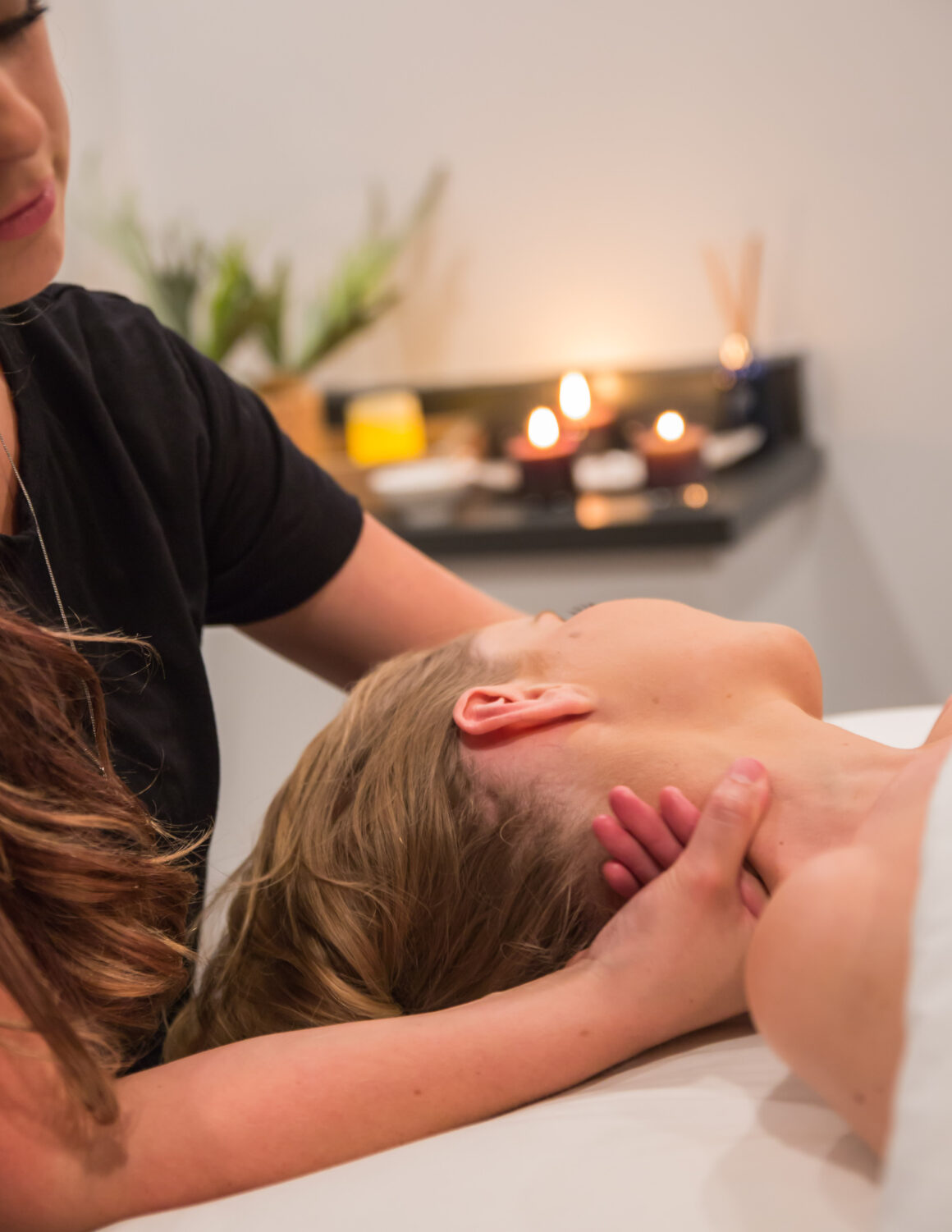Massage therapist gently supporting a client's neck during a relaxing massage treatment at Urban Oasis Nashville.