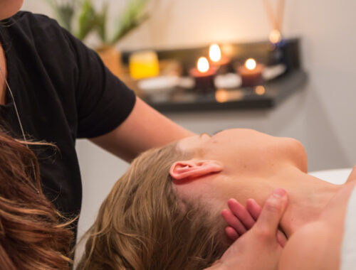 Massage therapist gently supporting a client's neck during a relaxing massage treatment at Urban Oasis Nashville.